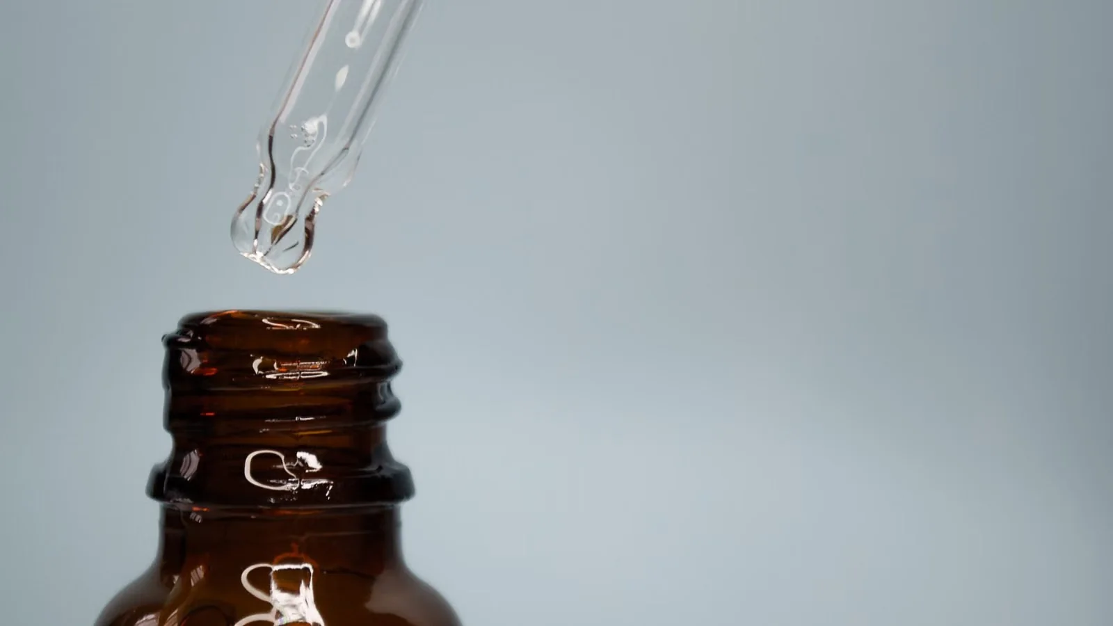 Amber cam şişenin üzerinde serum damlatan cam damlalık